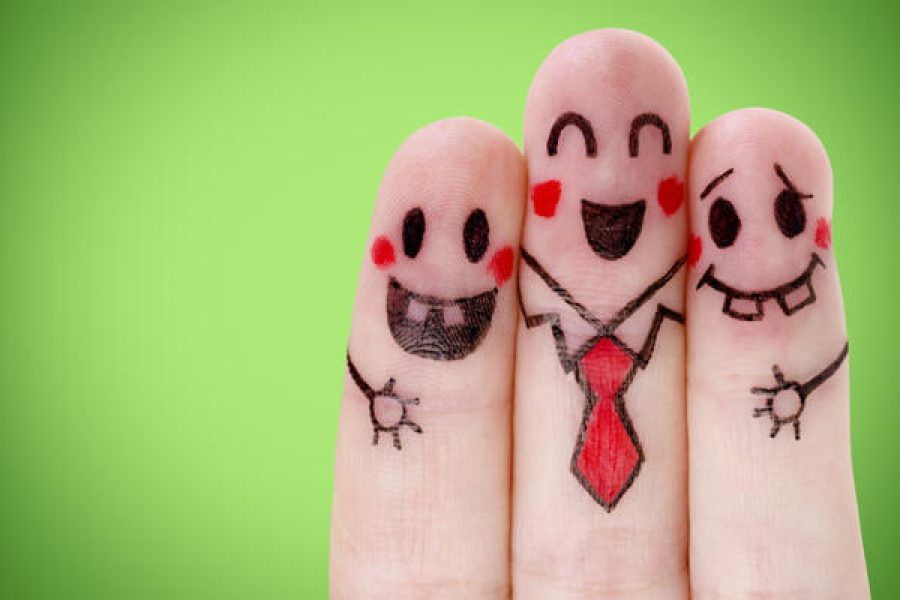 Fingers with happy smiley face on green