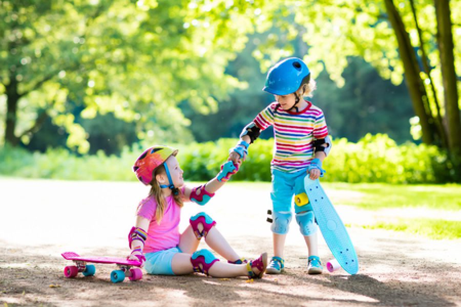 79156933 - children riding skateboard in summer park. little girl and boy learn to ride skate board, help and support each other. active outdoor sport for kids. child skateboarding. preschooler kid skating.